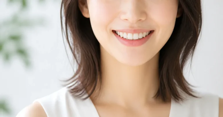 前歯と犬歯の自然な色の違いを確認する女性